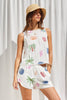 Woman wearing a sleeveless dress with colorful palm tree patterns against a white background