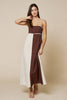 Woman wearing a two-tone dress with brown and white on a beige background