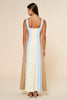 Woman wearing a long dress with color-blocked design on a beige background