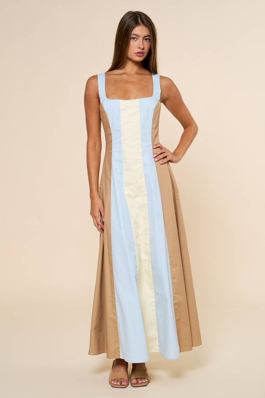 Woman wearing a long, multicolored dress with a beige background