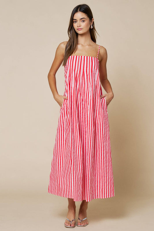 Woman wearing a red and white striped dress against a beige background